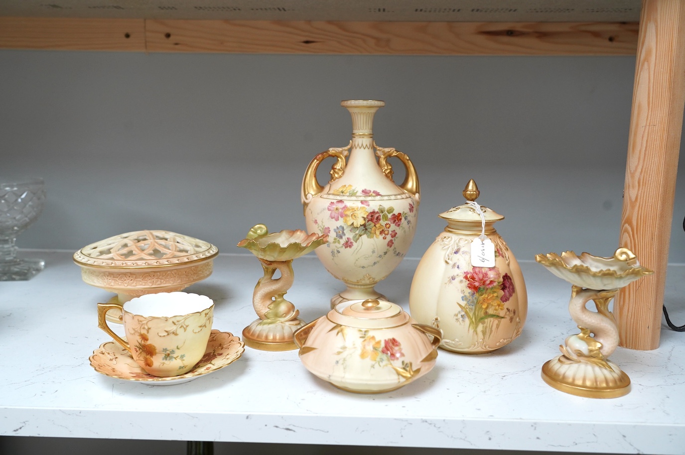 Royal Worcester blush ivory ornamental items: including a vase, two pots and covers, two dolphin stands, a cup and saucer and pierced bowl and cover (8). Condition - fair to good